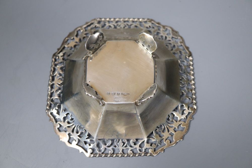 An Edwardian silver sugar basket, George V silver bon-bon dish, silver mounted match strike and a mug salt and spoon (4)